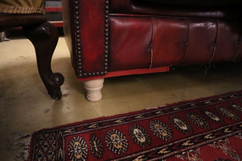 A buttoned red leather Chesterfield settee, width 194cm, depth 82cm, height 72cm